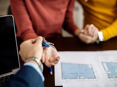 close up of real estate agent giving a couple keys of their new